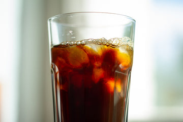 A glass with cold brew coffee and ice in it.