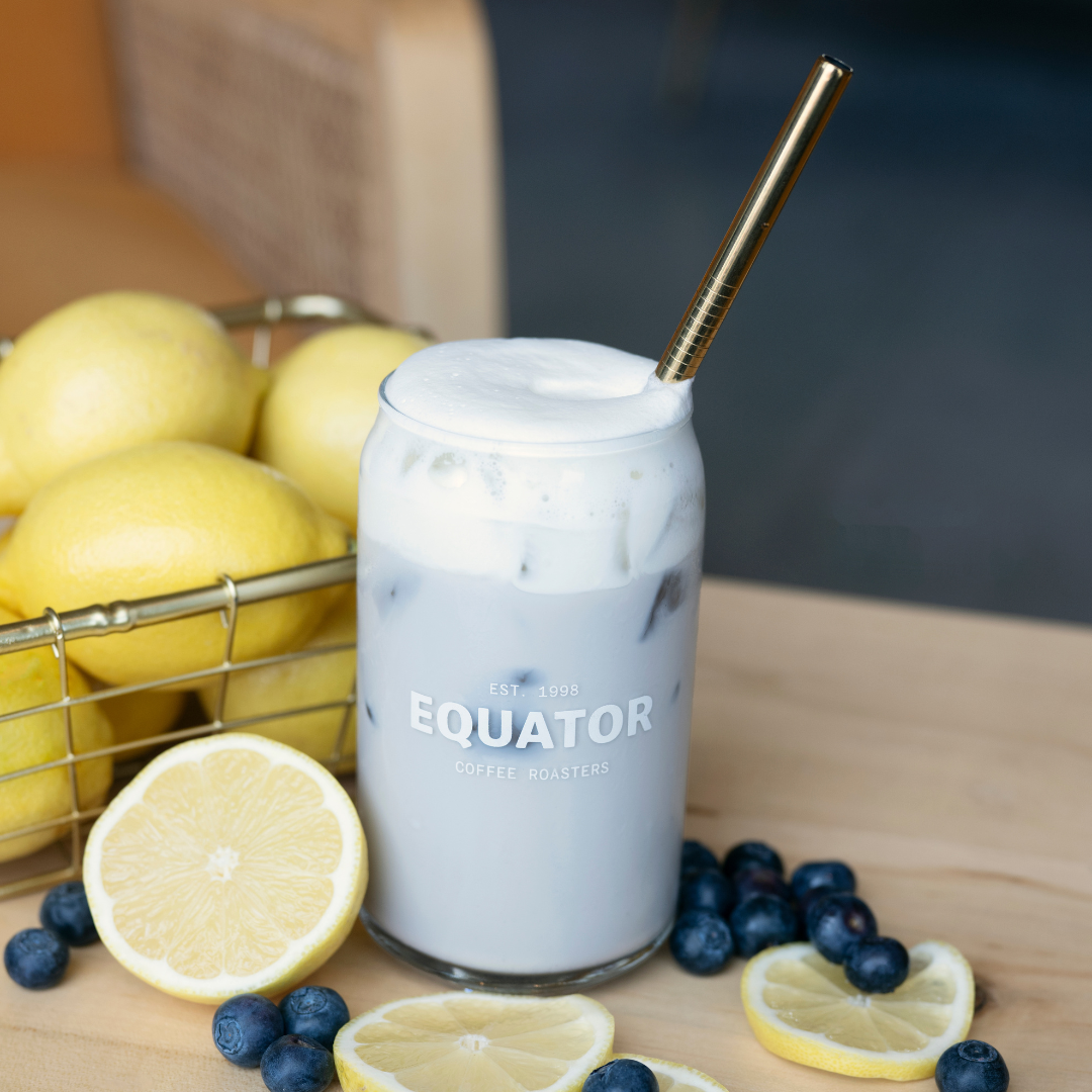 Rose gold coloured straw in a blueberry lemon fog with blueberries and lemons around it.