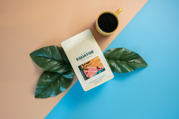 340g bag of Fall Seasonal coffee lying on some leaves with a cup of coffee beside it.