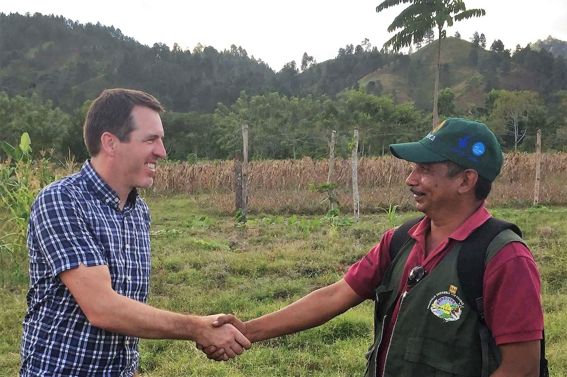 Craig shaking hands with a coffee farmer.