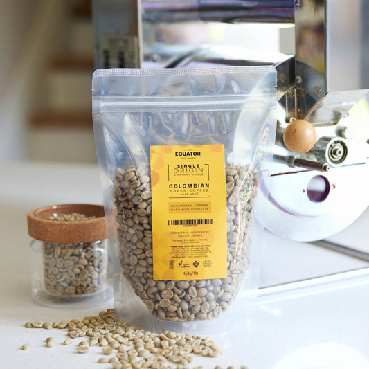 Resealable package of unroasted beans from Colombia with a home roaster in the background.