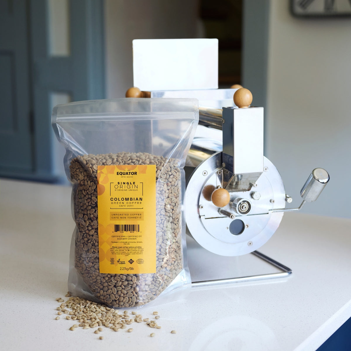 5lb bag of unroasted Colombian green beans with a home roaster behind it.