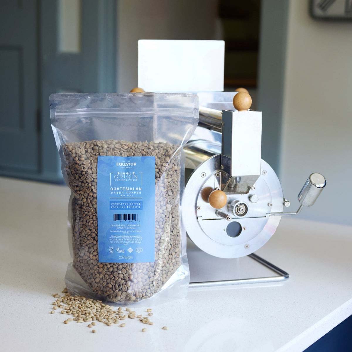 5lb bag of green coffee from Guatemala in front of a silver home roaster.