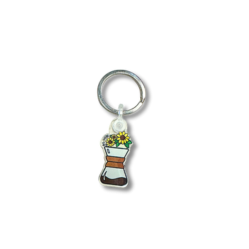 Keychain with sunflowers at the top of a Chemex.