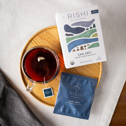 Rishi Tea packages with a cup of tea on a wooden tray