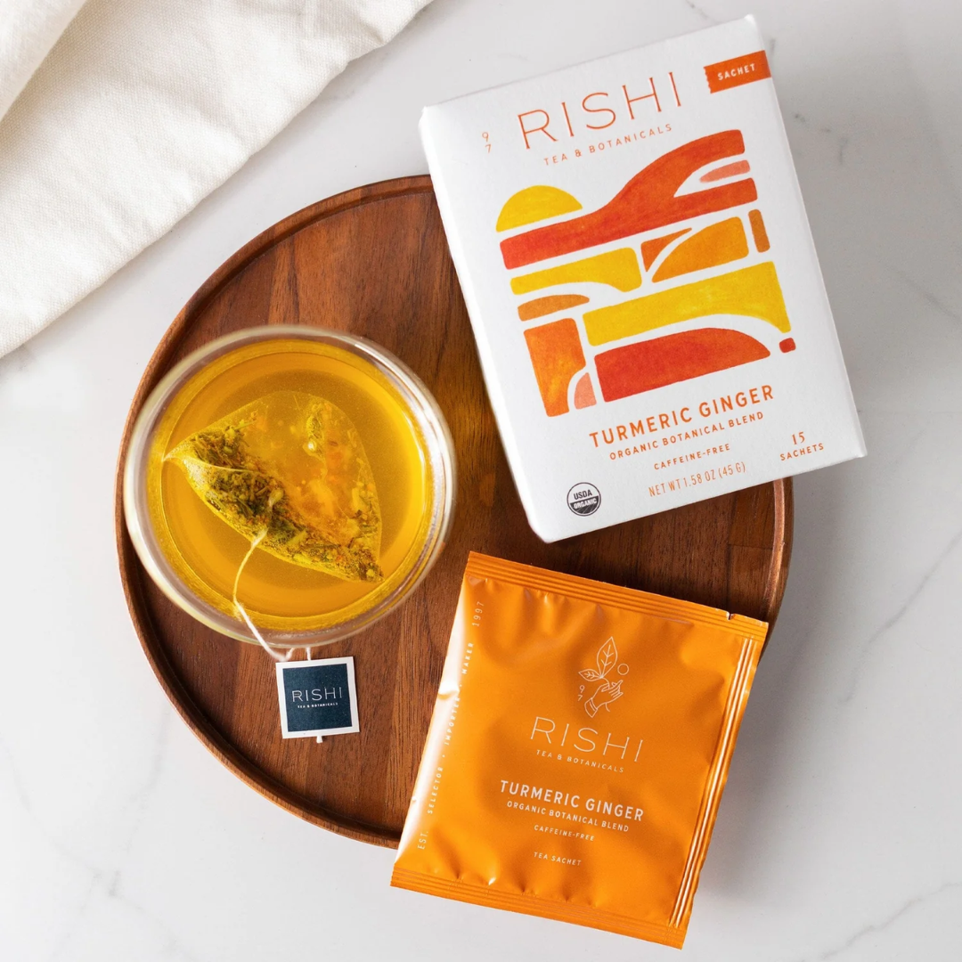 Rishi Turmeric Ginger tea packaging and a cup of tea on a wooden tray