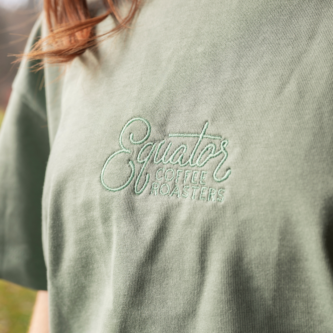 Green t-shirt with 'Equator Coffee Roasters' logo on it.