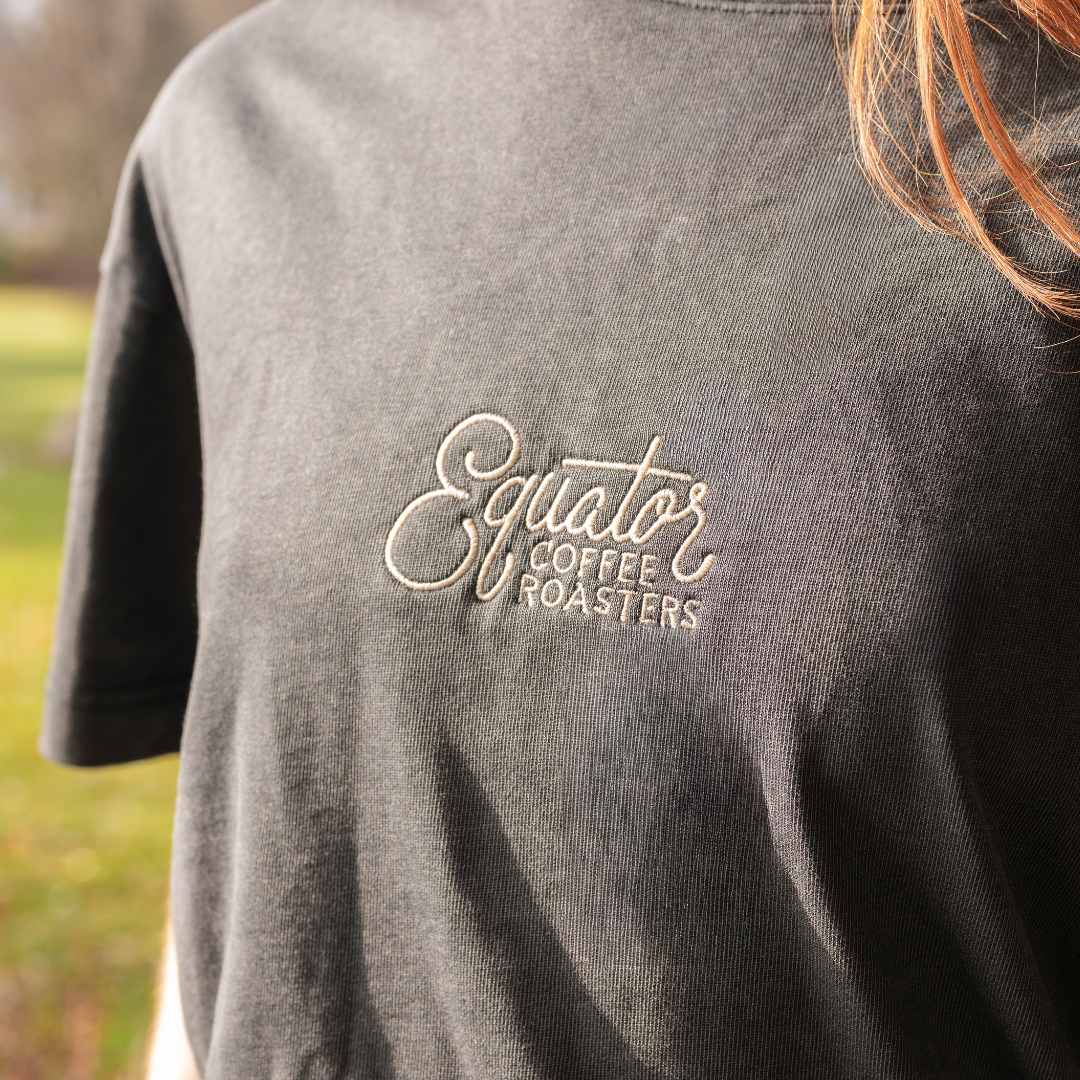 Person wearing a black t-shirt with 'Equator Coffee Roasters' logo.