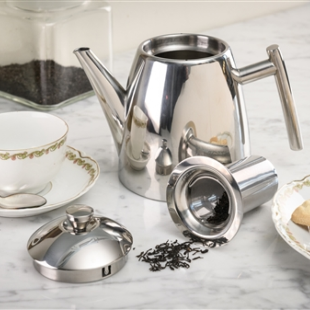 Frieling teapot and accessories on a marble counter with tea cup.