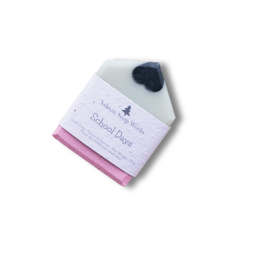 A pencil-shaped soap bar wrapped in a white paper label that reads 'Ashton Soap Works School Days'. The soap looks like a pencil - Equator Coffee Roasters