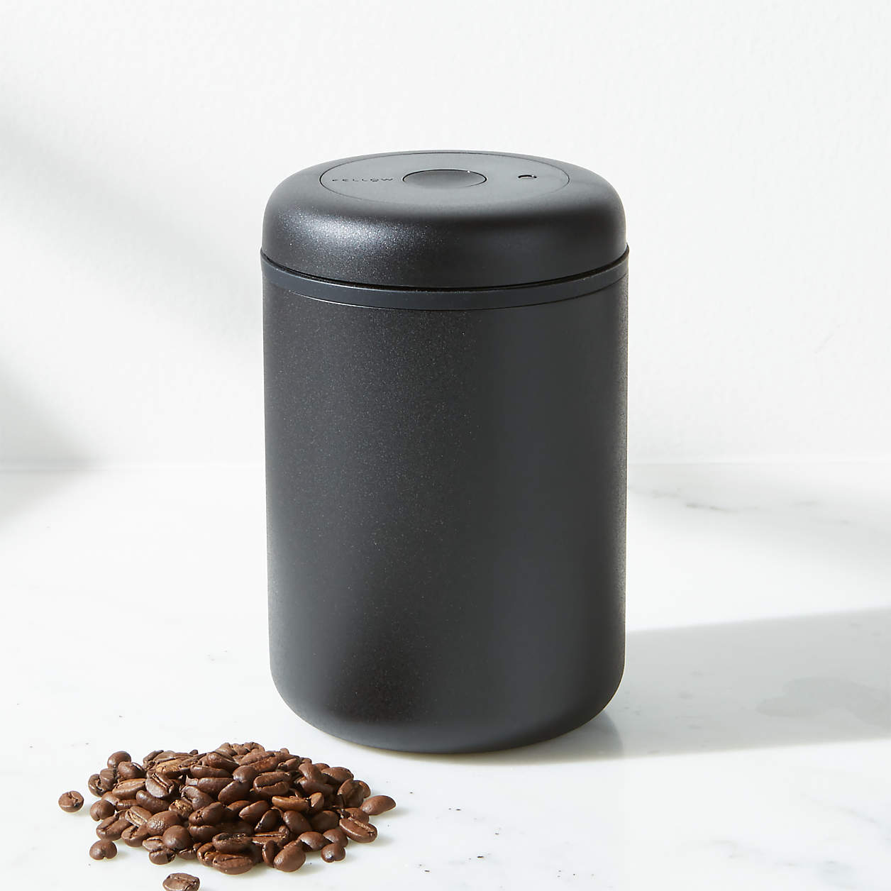 Small scoop of coffee beans and a Fellow Atmos Vacuum Canister 1.2L in Matte Black
