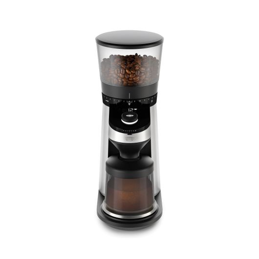 Conical Burr Grinder with scale pictured with coffee beans in the top hopper and grinds in the grind cup.